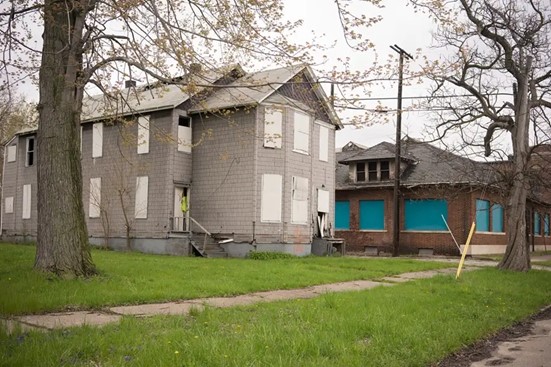 A house with a blue door in Detroit, MI representing the benefits of selling a home needing repairs